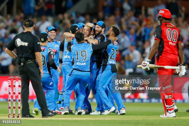 Adelaide Strikers players celebrate winning as a dejected Kieron Pollard of the Renegades look on after the Big Bash League match between the...