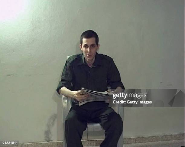 In this video-grab made available by the Hamas on October 2 captured Israeli soldier Gilad Shalit is seen holding a Palestinian newspaper dated...