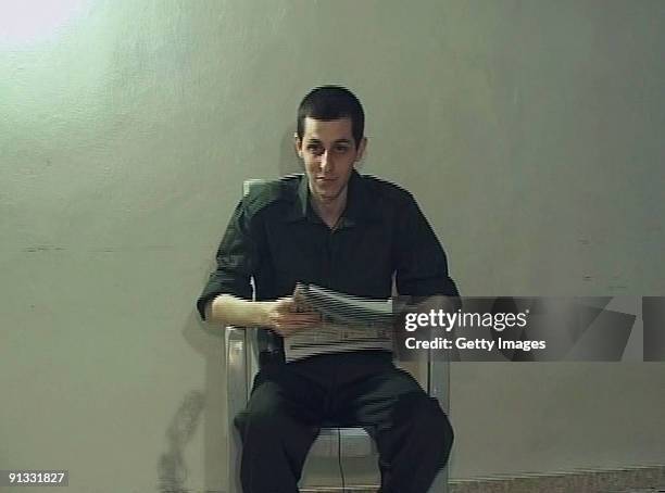 In this video-grab made available by the Hamas on October 2 captured Israeli soldier Gilad Shalit is seen holding a Palestinian newspaper dated...