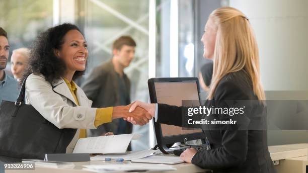 greffier de location femelle donnant les documents aux clients femmes location voiture - bank counters photos et images de collection