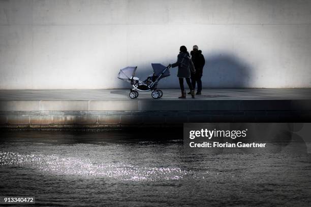 Two women with a buggy talk next to the river Spree on February 01, 2018 in Berlin, Germany.