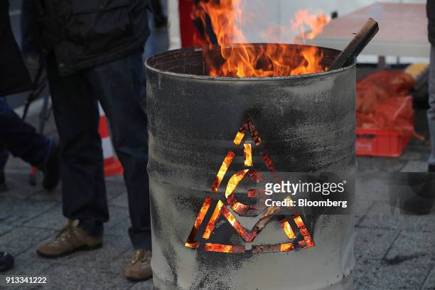 The IG Metall logo sits on a burning brazier barrel during a 24 hour strike called by the labor union outside the BMW Motorrad motorcycle factory,...