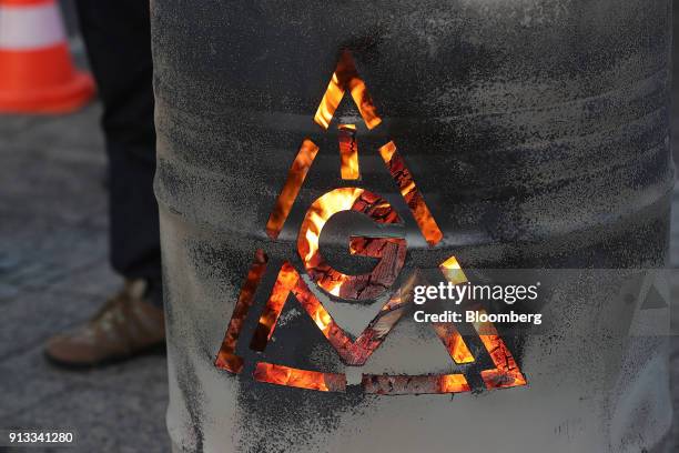 The IG Metall logo sits on a burning brazier barrel during a 24 hour strike called by the labor union outside the BMW Motorrad motorcycle factory,...