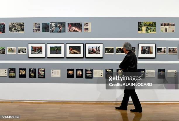 Man looks at pictures of US Photographer Susan Meiselas at the Jeu de Paume museum on February 2 in Paris. / RESTRICTED TO EDITORIAL USE - MANDATORY...