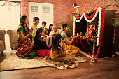 Indian  family performing Ganesh puja or Ganpati Puja in Ganesh Utsav, or holding ganesh idol over white background