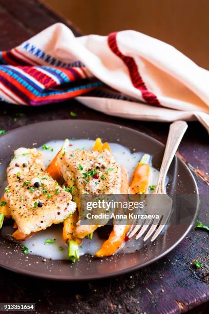 roasted white fish fillet with cream sauce and baby carrots on a plate, selective focus - peppercorn sauce stock pictures, royalty-free photos & images
