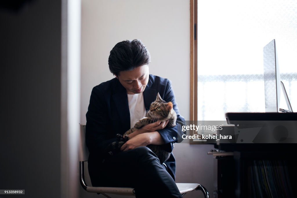 Business man communicating with his cat at home office