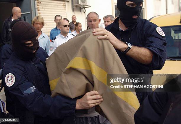 Elite French police members of Ajaccio arrest an armed man who had taken three people hostage at a post office in the city of Ajaccio on the southern...