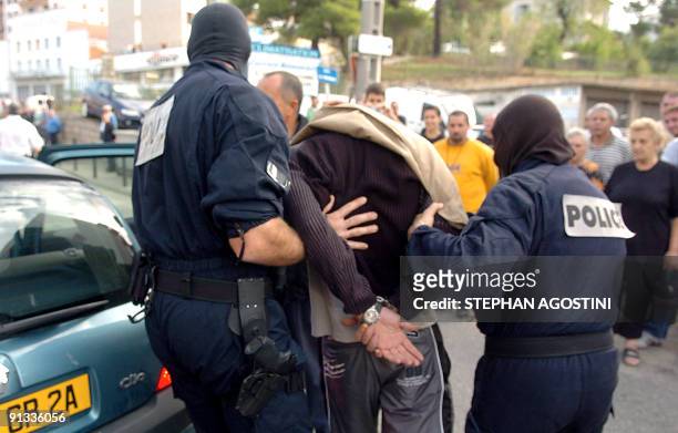 Elite French police members of Ajaccio arrest an armed man who had taken three people hostage at a post office in the city of Ajaccio on the southern...