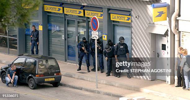 Elite French police members of Ajaccio get ready to storm a post office in the city of Ajaccio on the southern French island 03 October 2006, while...