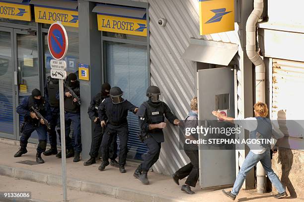 Elite French police members of Ajaccio storm a post office in the city of Ajaccio on the southern French island 03 October 2006, while an armed man...