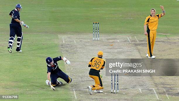 Australia's wicket keeper Tim Paine successfully runs-out England's Graeme Swann as Shane Watson and Tim Bresnan watch during the ICC Champions...