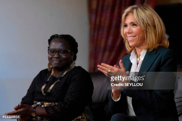 Wife of French President Brigitte Macron aplauds next to Catherine Sarr Sambou, director of Mariama Ba school on the island of Goree, once a west...