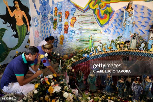 Faithfuls pray at an altar at Rio Vermelho beach in Salvador, Bahia state, Brazil, during celebrations of Yemanja day, the goddess of the sea from...