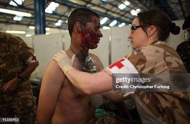 Mock casualty is given medical assistance by volunteers from 256 Field Hospital during an exercise at the Army Medical Services Training Centre, on...