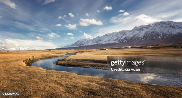 stream flowing through the grassland on the pamirs,tashkurgan,china - silk road photos et images de collection