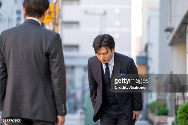 成熟した日本のビジネスマンに敬意を示すお辞儀 - お辞儀 ストックフォトと画像