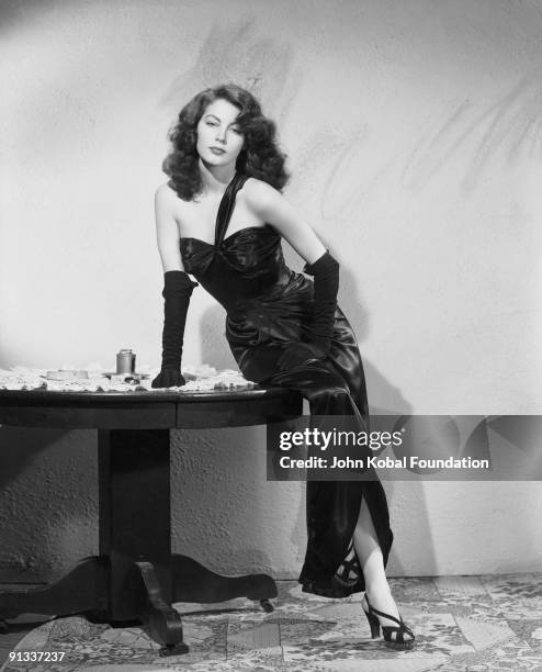 American actress Ava Gardner in black satin dress and gloves, as femme fatale Kitty Collins in 'The Killers', directed by Robert Siodmak, 1946.