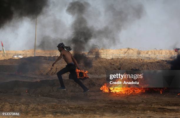 Palestinian protesters burn tyres in response to Israeli security forces' intervention during a protest against U.S. President Donald Trumps...