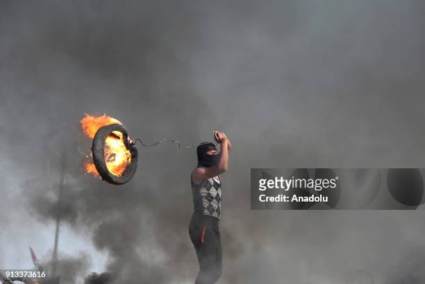 Palestinian protesters burn tyres in response to Israeli security forces' intervention during a protest against U.S. President Donald Trumps...