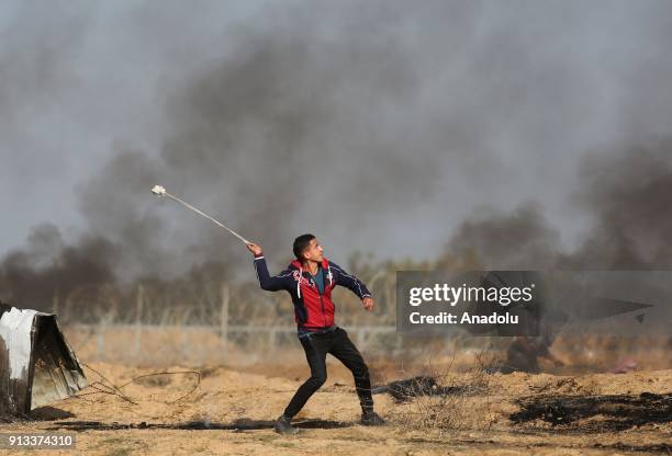 Palestinian protesters burn tyres and throw stones in response to Israeli security forces' intervention during a protest against U.S. President...