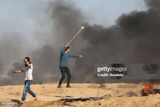 Palestinian protesters burn tyres and throw stones in response to Israeli security forces' intervention during a protest against U.S. President...