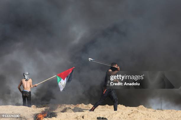 Palestinian protesters burn tyres and throw stones in response to Israeli security forces' intervention during a protest against U.S. President...