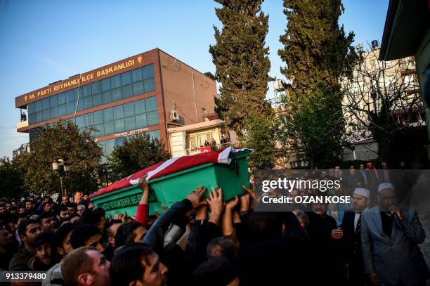 People carry a coffin covered with a Turkish flag during a funeral cerenomy for a man killed by rocket fire in Reyhanli, a town close to the Syrian...