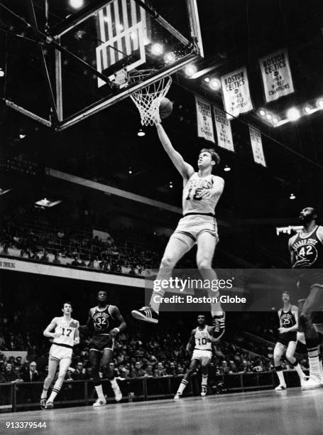 Boston Celtics Dave Cowens, center, shoots for a basket during a game against the Golden State Warriors at the Boston Garden, March 14, 1972. From...