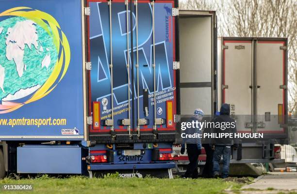 A group of migrants walk next to a lorry on February 2, 2018 in Calais. Four migrants were fighting for their lives on February 2, 2018 after being...