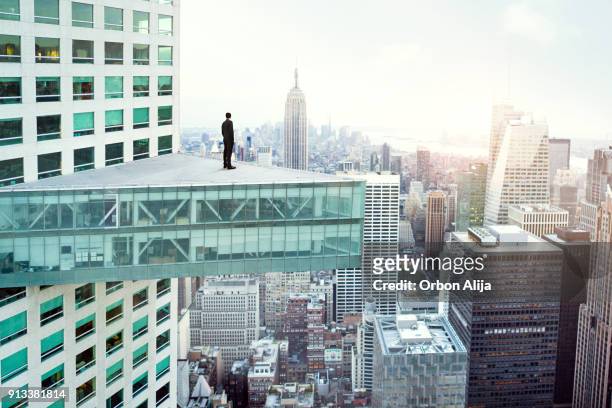 young man looking out at city skyline in new york - skyscraper stock pictures, royalty-free photos & images