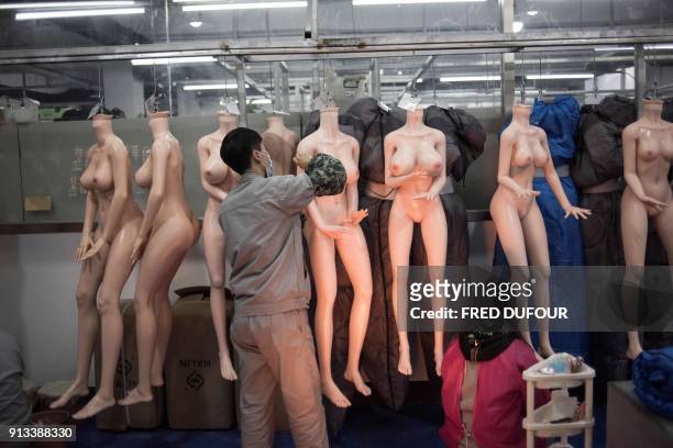 Graphic content / This photo taken on February 1, 2018 shows a worker preparing silicone dolls at a factory of EXDOLL, a firm based in the...