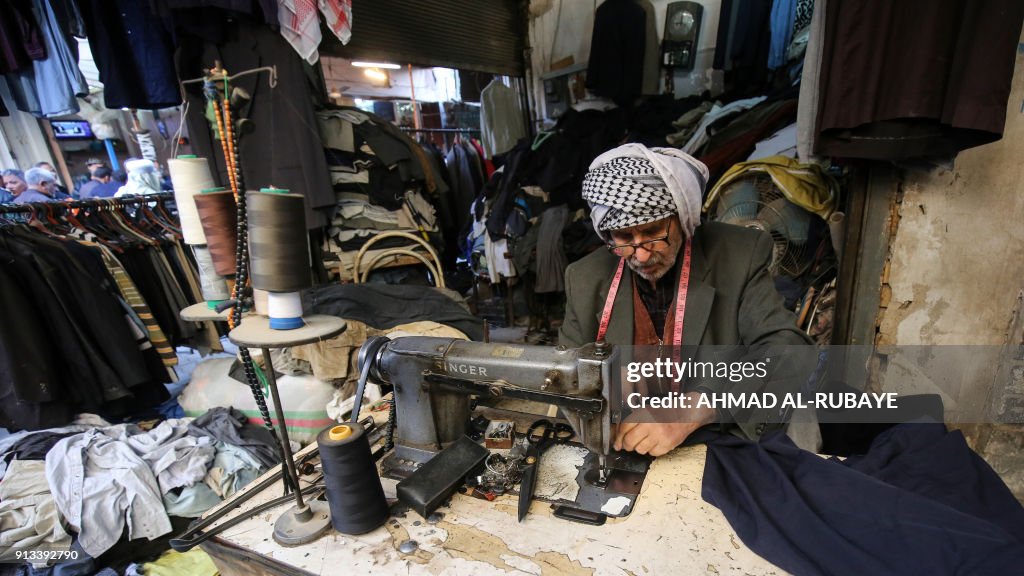 Iraq Textile An Iraqi tailor sews a garment as he sits in his shop in the market ...