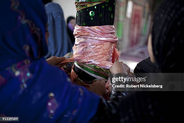 Worshippers tie a bright cloth, or janda, on a pole at the Ziarat-i-Sakhi shrine in Kabul, Afghanistan March 4, 2009. The shrine is famous for when...