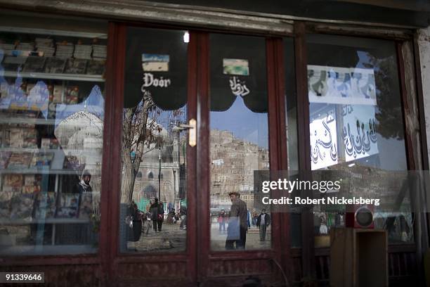 Worshippers walking to the Ziarat-i-Sakhi shrine are reflected in a shop window in Kabul, Afghanistan March 4, 2009. The shrine is famous for when it...