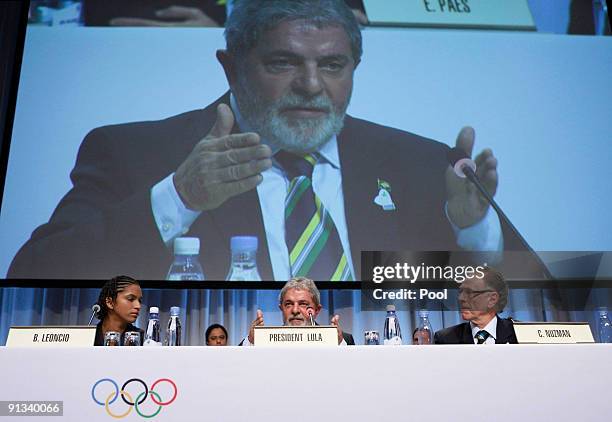 Brazil's President Luiz Inacio Lula da Silva sits between Carlos Nuzman, President of Rio 2016, right, and Track and Field Olympian Barbara Leoncio...