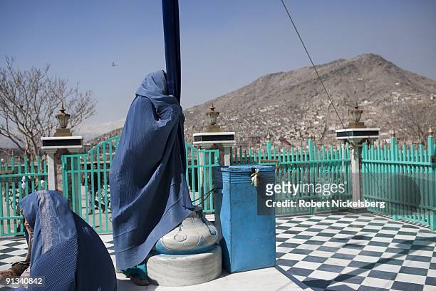 Worshippers pray at a cloth covered pole, or alam mubarak, at the Ziarat-i-Sakhi shrine in Kabul, Afghanistan March 4, 2009. The shrine is famous for...