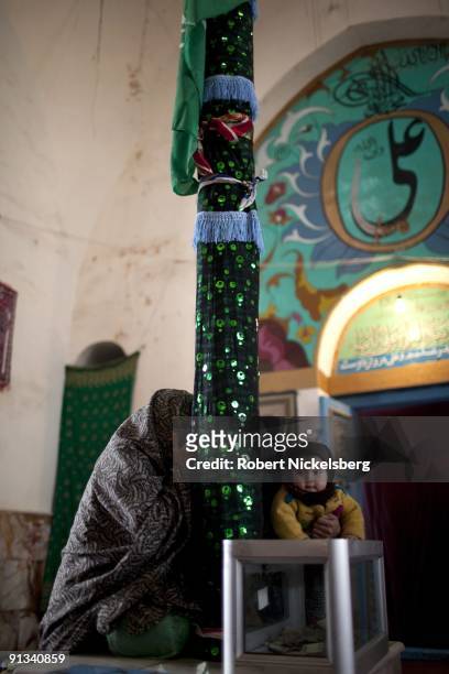 Worshippers pray at a cloth covered pole, or alam mubarak, at the Ziarat-i-Sakhi shrine in Kabul, Afghanistan March 2, 2009. The shrine is famous for...
