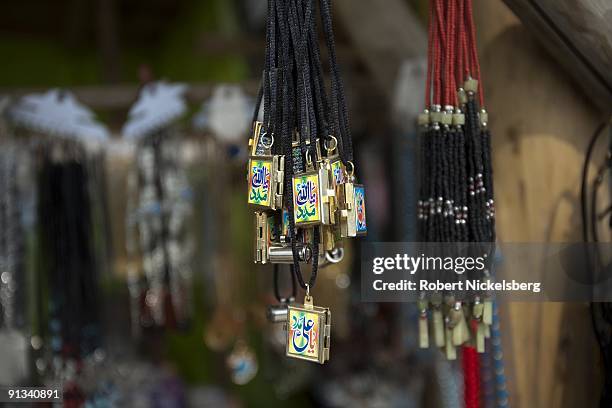 Colorful lockets with islamic inscriptions hang in a shopkeepers stall outside the Ziarat-i-Sakhi shrine in Kabul, Afghanistan March 2, 2009. The...