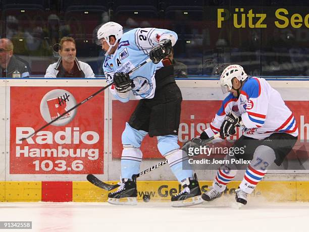 John Tripp of Hamburg and Shane Peacock of Nuernberg fight for the puck during the DEL match between Hamburg Freezers and Nuernberg Ice Tigers at the...