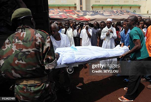 Soldiers unload bodies of victims shot dead by Guinea junta forces at the September 28, 2009 demonstration in front of the Conakry great mosque on...