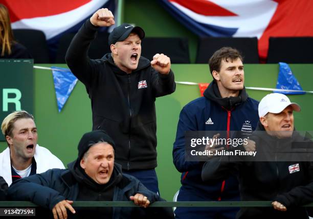 Liam Broady, Kyle Edmund and Jamie Murray celebrate Cameron Norrie of Great Britain winning a game against Roberto Bautista Agut of Spain during day...