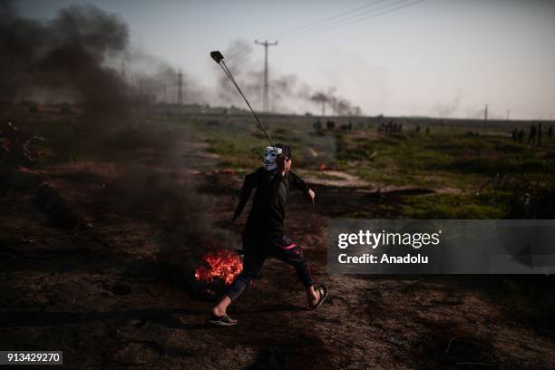 Palestinian protesters burn tyres and throw stones in response to Israeli security forces' intervention during a protest against U.S. Decision to...