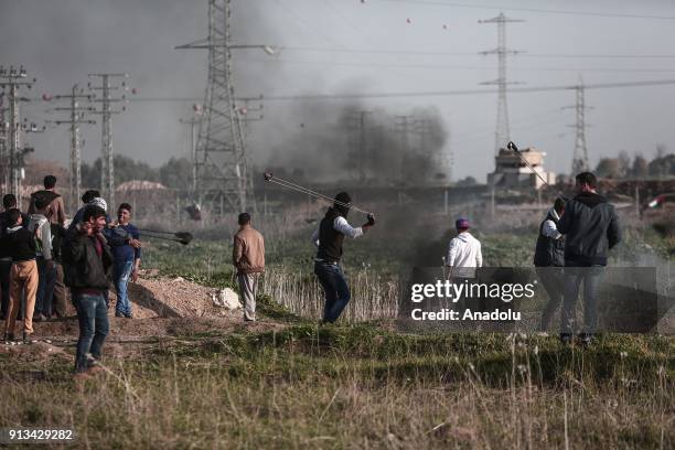 Palestinian protesters burn tyres and throw stones in response to Israeli security forces' intervention during a protest against U.S. Decision to...