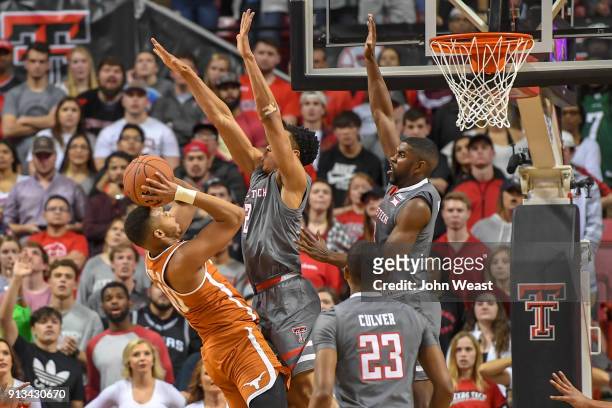 Eric Davis Jr. #10 of the Texas Longhorns tries to shoots the ball over Zhaire Smith of the Texas Tech Red Raiders and Josh Webster of the Texas Tech...
