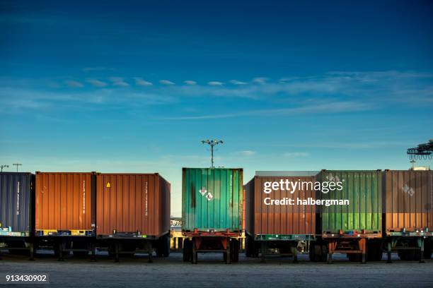 ligne de conteneurs d’expédition sur les camions - récipient photos et images de collection