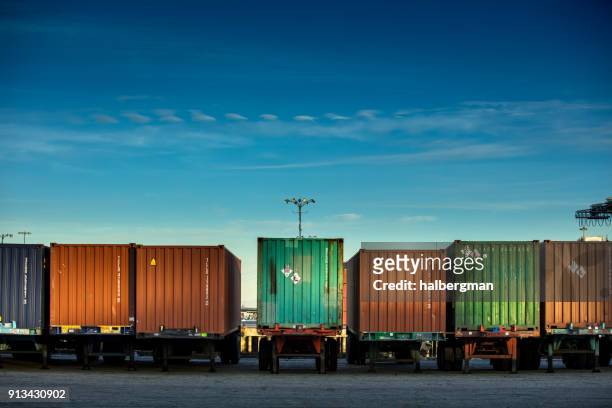 line of shipping containers on trucks - container stock pictures, royalty-free photos & images