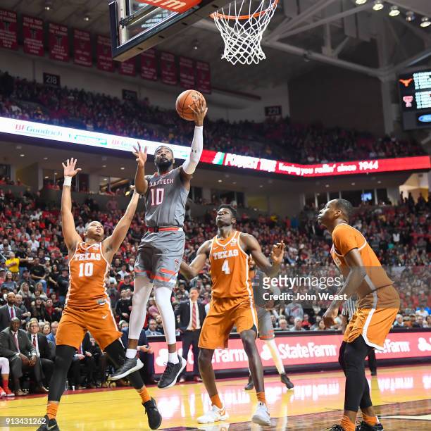 Niem Stevenson of the Texas Tech Red Raiders goes to the basket against Eric Davis Jr. #10 of the Texas Longhorns and Mohamed Bamba of the Texas...
