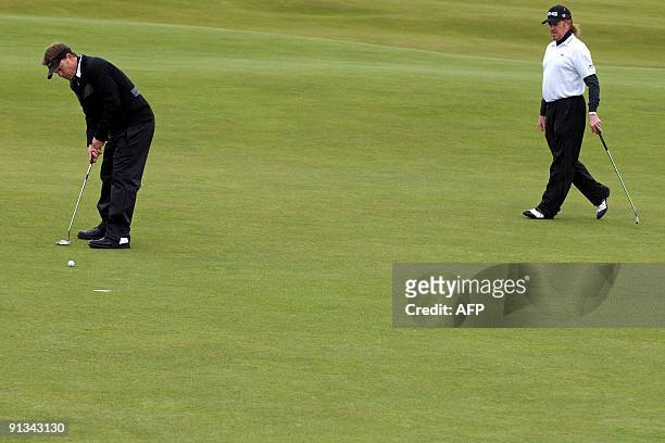 Actor Greg Kinnear putts as Spanish golfer Miguel Angel Jimenez looks on, on the St Andrews Old Course, in St Andrews, in Scotland, on the second day...