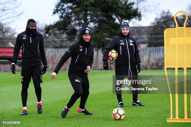 Isaac Hayden dribbles the ball whilst Chancel Mbemba and Newcastle United Head of Analysis and First Team Coach Antonio Gomez Perez look on during...